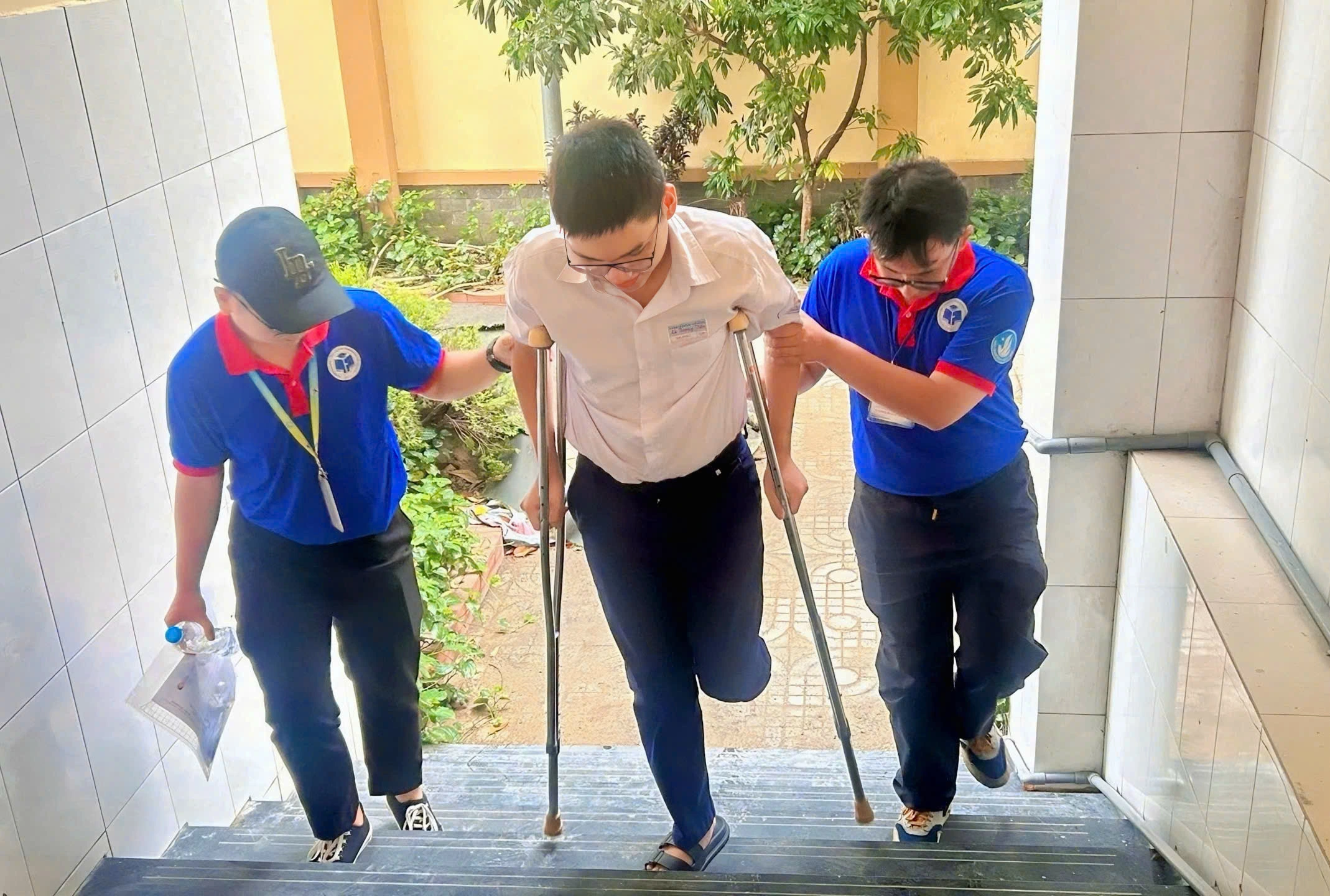 Thí sinh bị gãy chân, di chuyển bằng nạng được tình nguyện viên tận tình hỗ trợ