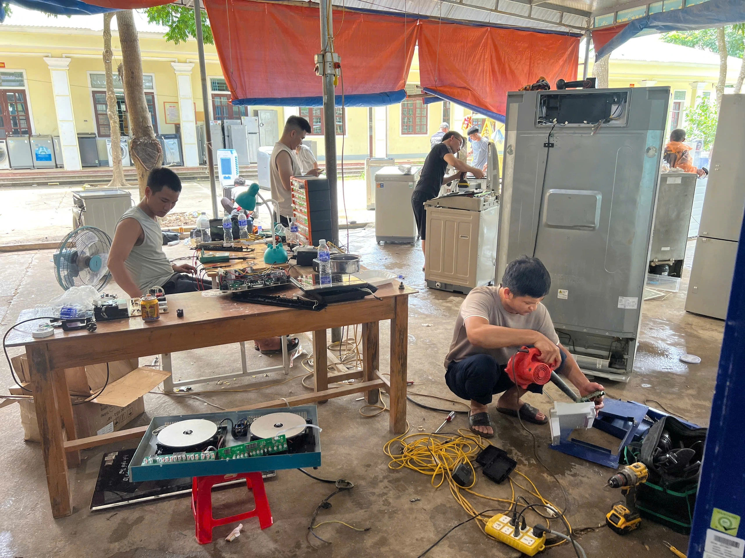 Nhiều bạn trẻ đến vùng lũ sửa chữa thiết bị gia dụng miễn phí cho bà con