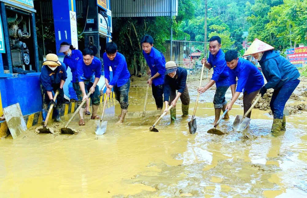 'Áo xanh' giúp người dân cào bùn dọn lũ